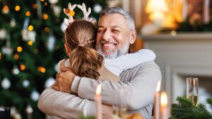 Ein kleines Mädchen nimmt ihren Großvater an Weihnachten dankbar in den Arm