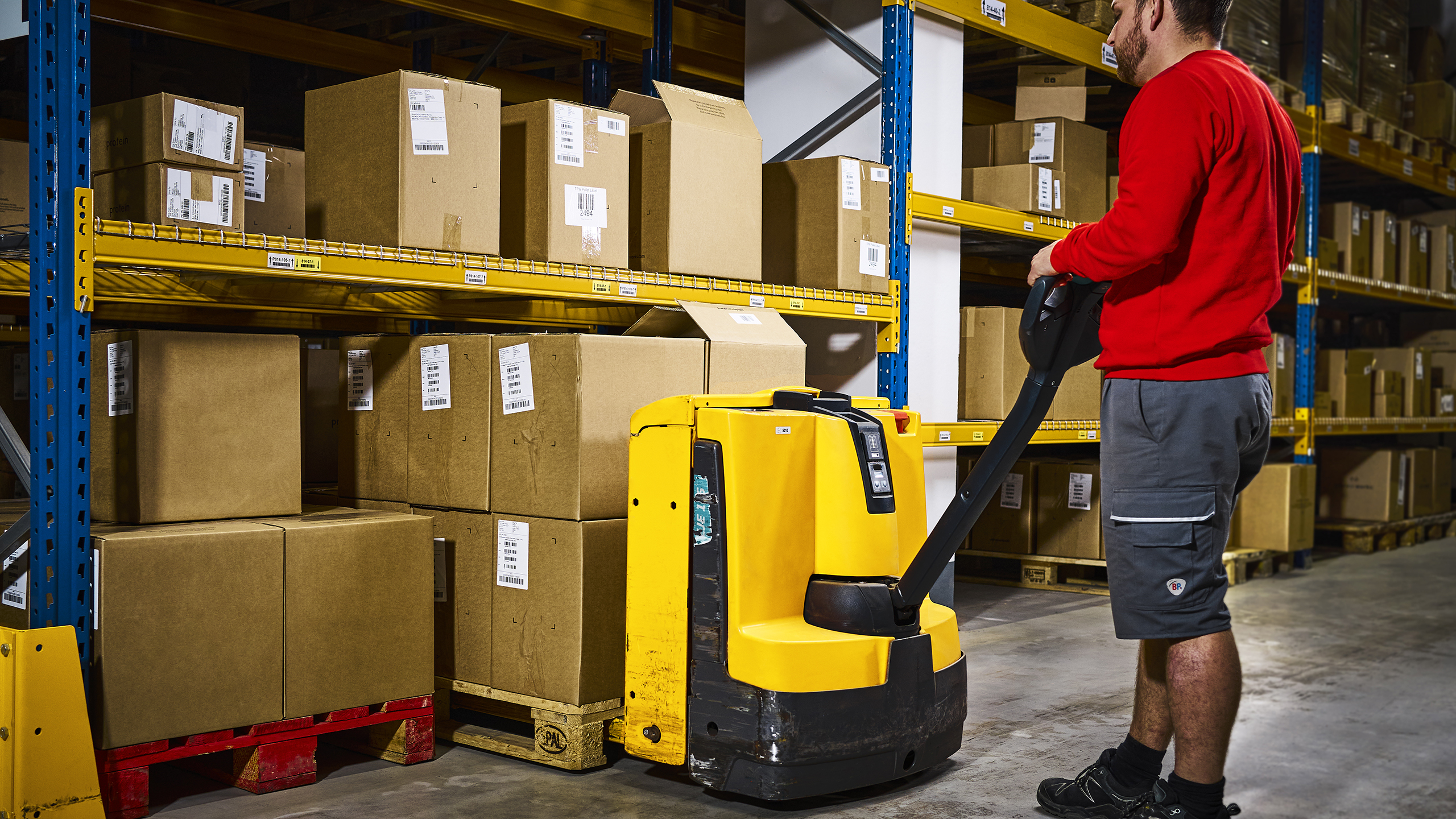 An employee in the fulfillment warehouse sorts a pallet loaded with parcels in the warehouse