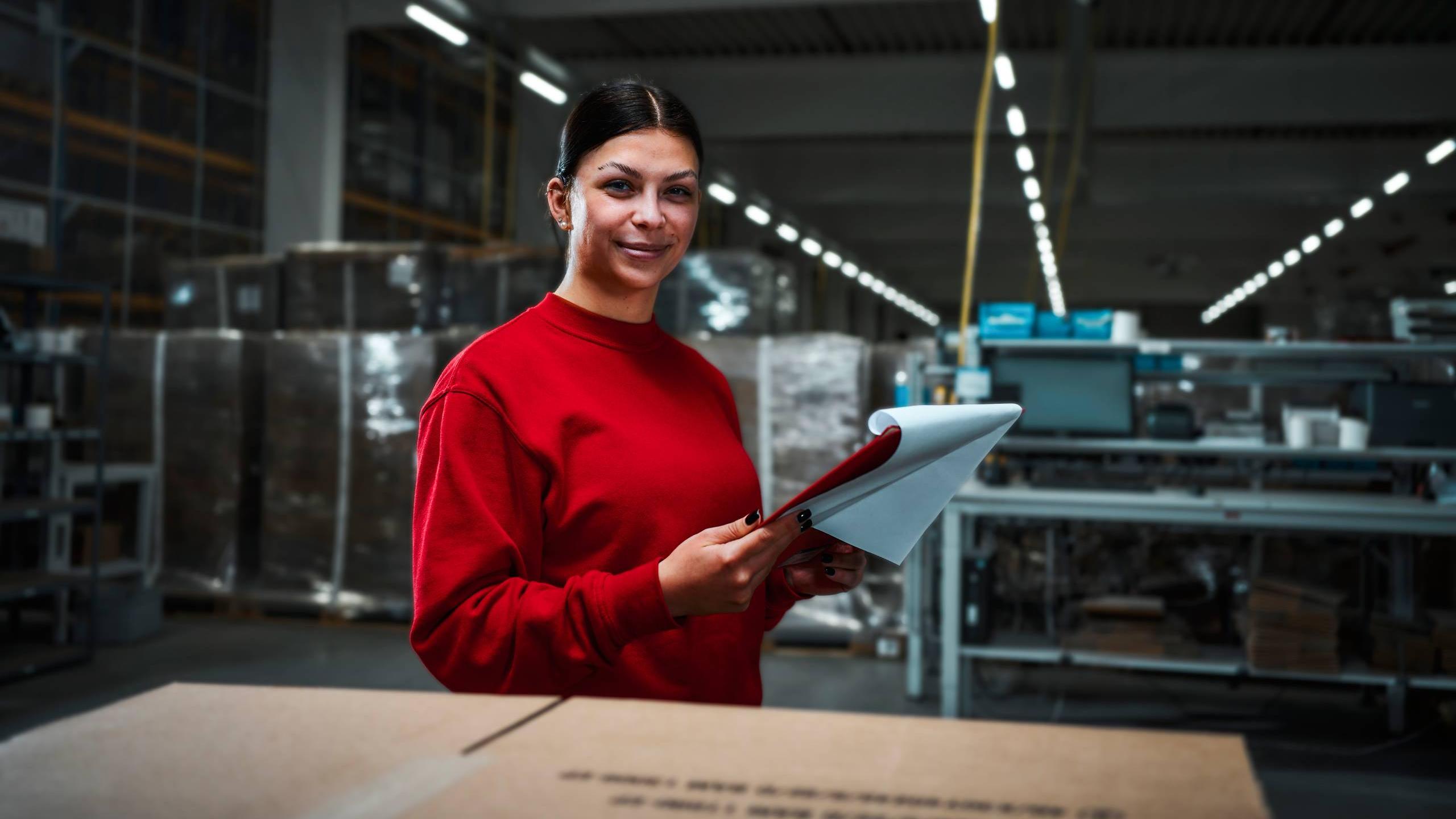 A shipping employee places an order on a conveyor belt in shipping